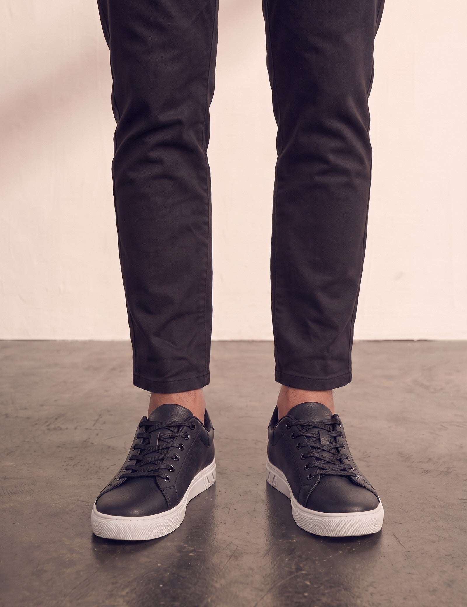Men's Black Faux Leather Minimalist Low-Top Trainers, front view of the shoes, worn.