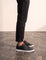 Men's Black Faux Leather Minimalist Low-Top Trainers, side view of the shoe, worn.