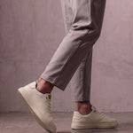 Men's Taupe Faux Leather Low-Top Trainers, the shoes in mid-step, showing the sole.