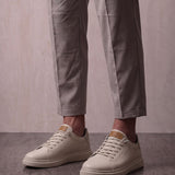 Men's Taupe Faux Leather Low-Top Trainers, three-quarter front view of the shoes, worn.