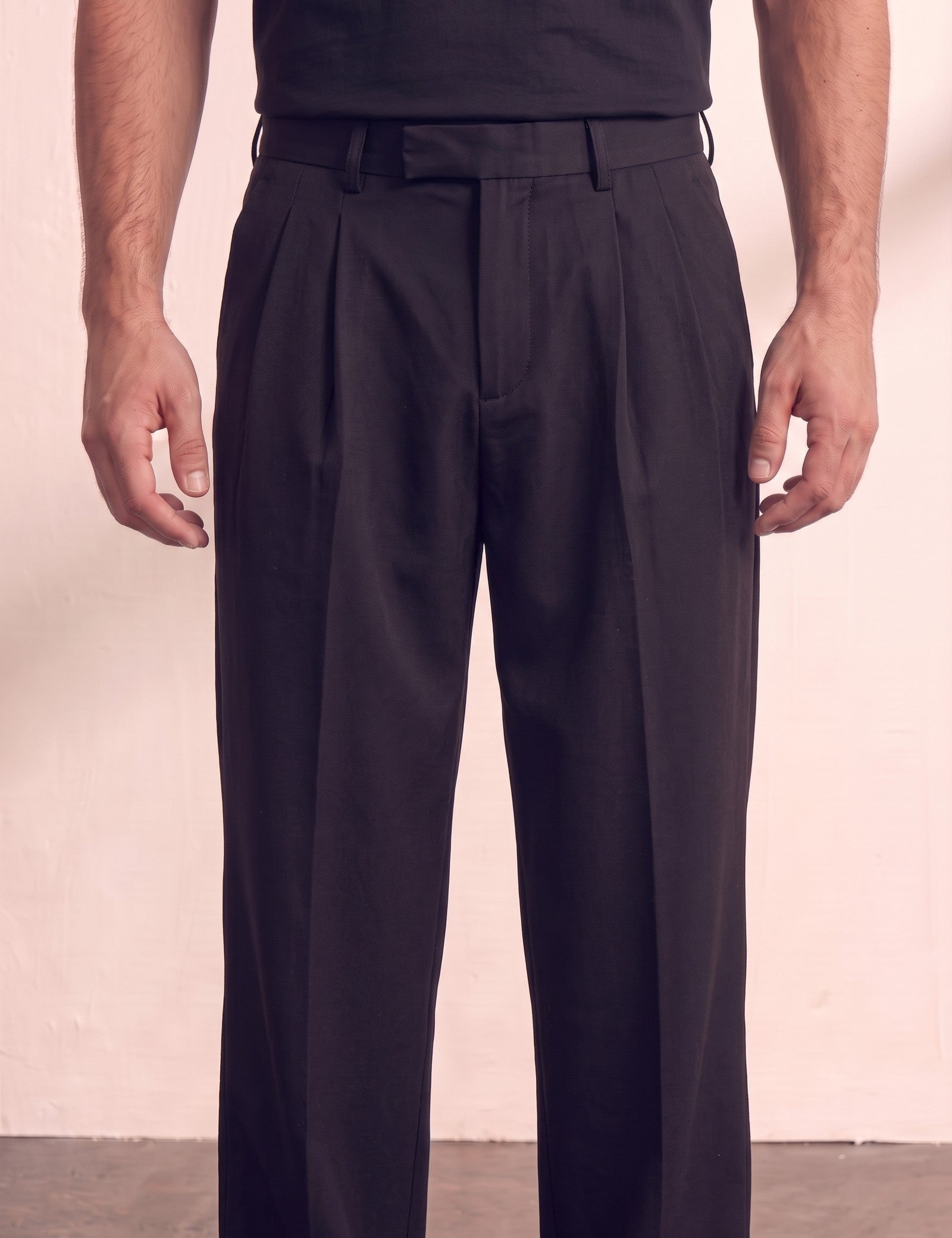Men's Black Wide Leg Pleated Trousers, close-up of the waistband and front pocket.
