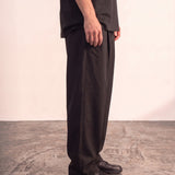 Men's Black Wide Leg Pleated Trousers, side view from the waist down.