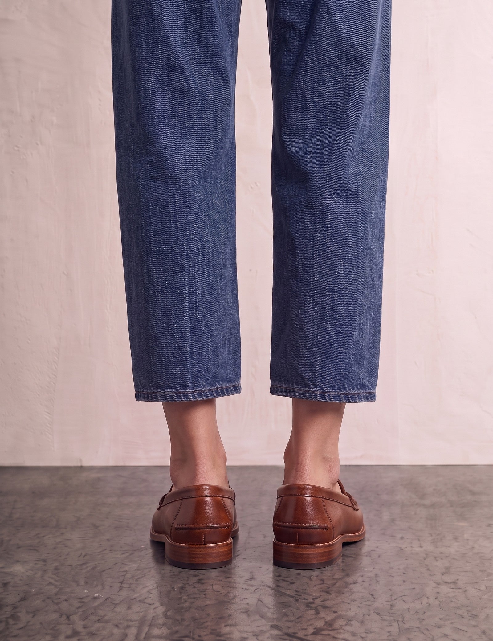 Men's Brown Penny Loafers with Moccasin Stitching, back view of the heels, worn.