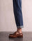 Men's Brown Penny Loafers with Moccasin Stitching, side view of the shoe, worn.