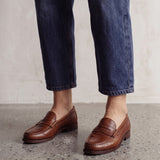 Men's Brown Penny Loafers with Moccasin Stitching, three-quarter front view of the shoes, worn.