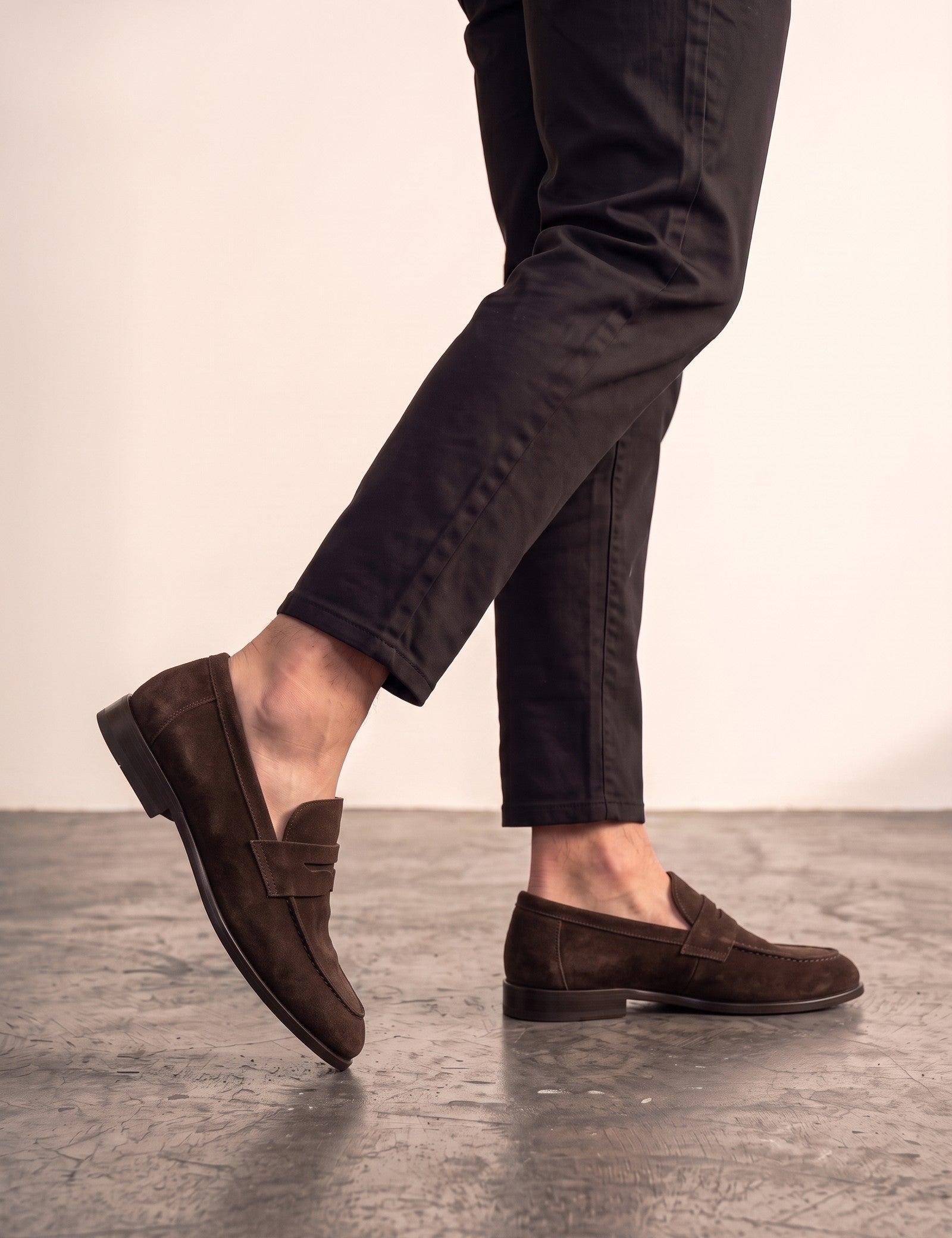 Men's Brown Suede-Effect Penny Loafers, the shoes in mid-step, showing the sole.