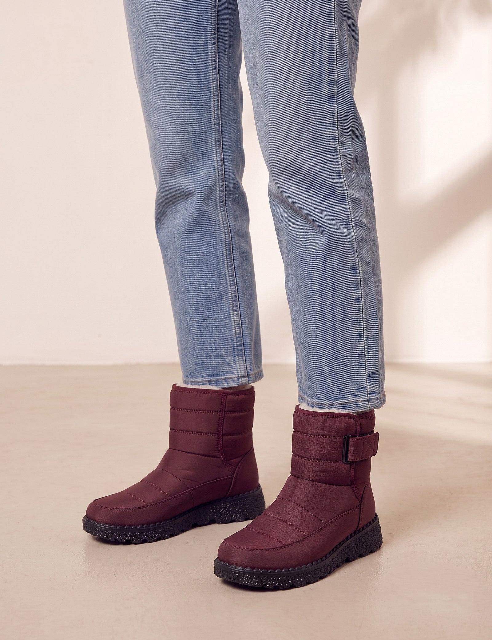 Men's Burgundy Quilted Snow Boots with Ankle Strap, three-quarter front view of the shoes, worn.