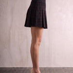 Women's Black and Red Tartan High Waisted Pleated Mini Skirt, side view from the waist down.
