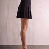 Women's Black and Red Tartan High Waisted Pleated Mini Skirt, side view from the waist down.