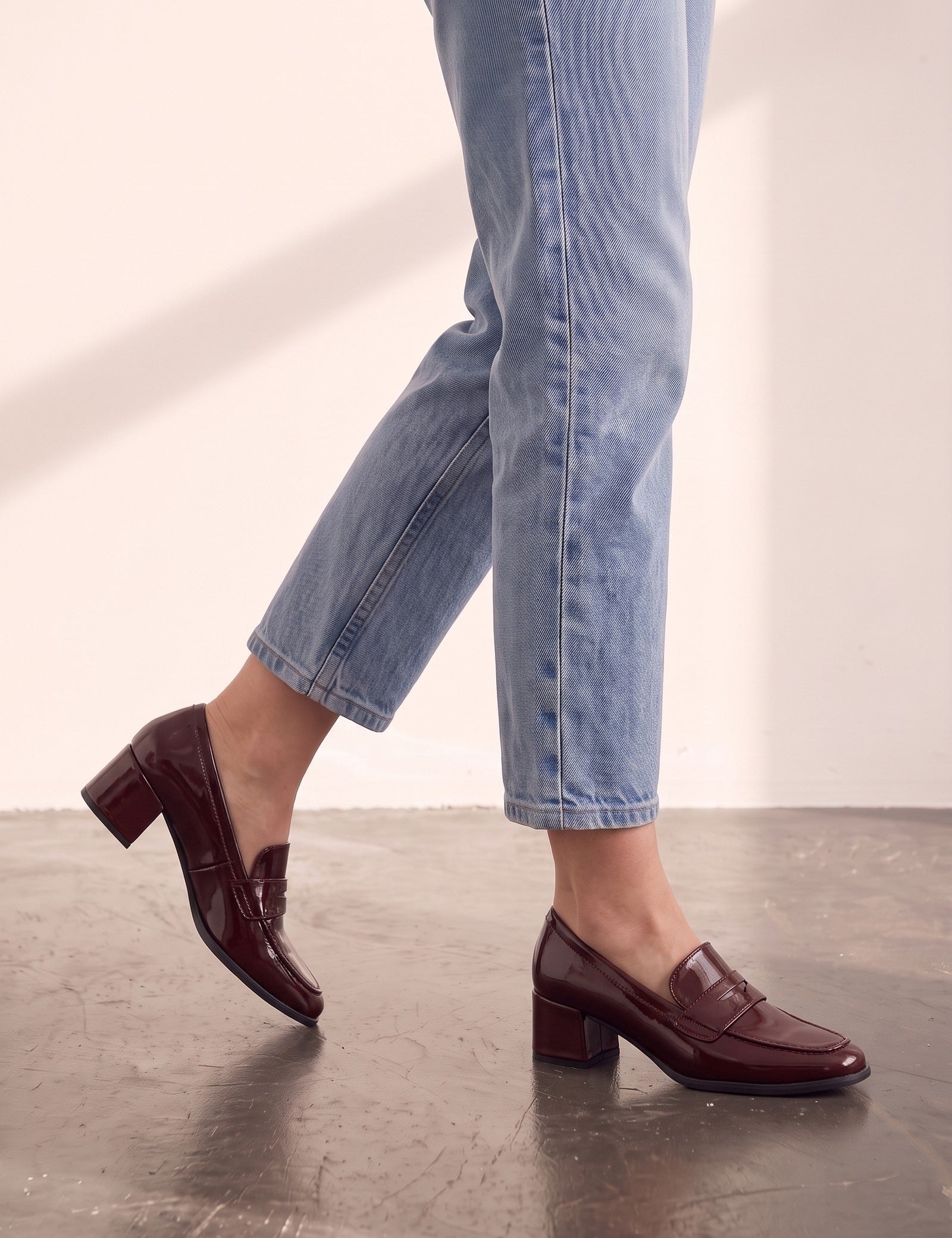 Women's Burgundy Patent Block Heel Loafers, the shoes in mid-step, showing the sole.