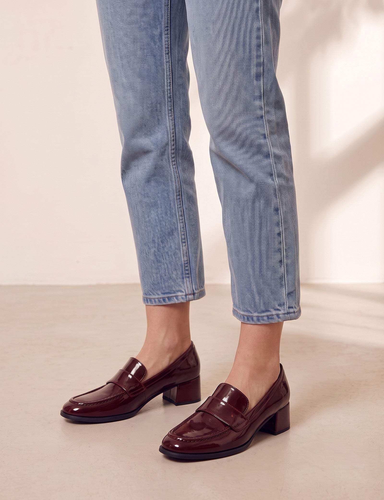 Women's Burgundy Patent Block Heel Loafers, three-quarter front view of the shoes, worn.