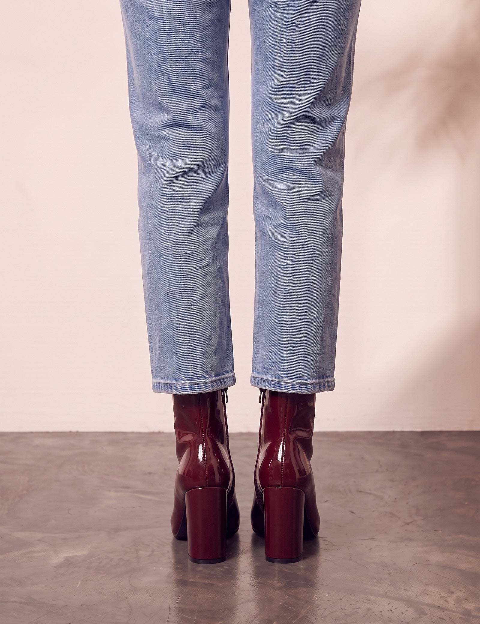 Women's Burgundy Patent Pointed Block Heel Ankle Boots, back view of the heels, worn.