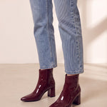 Women's Burgundy Patent Pointed Block Heel Ankle Boots, three-quarter front view of the shoes, worn.