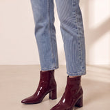 Women's Burgundy Patent Pointed Block Heel Ankle Boots, three-quarter front view of the shoes, worn.