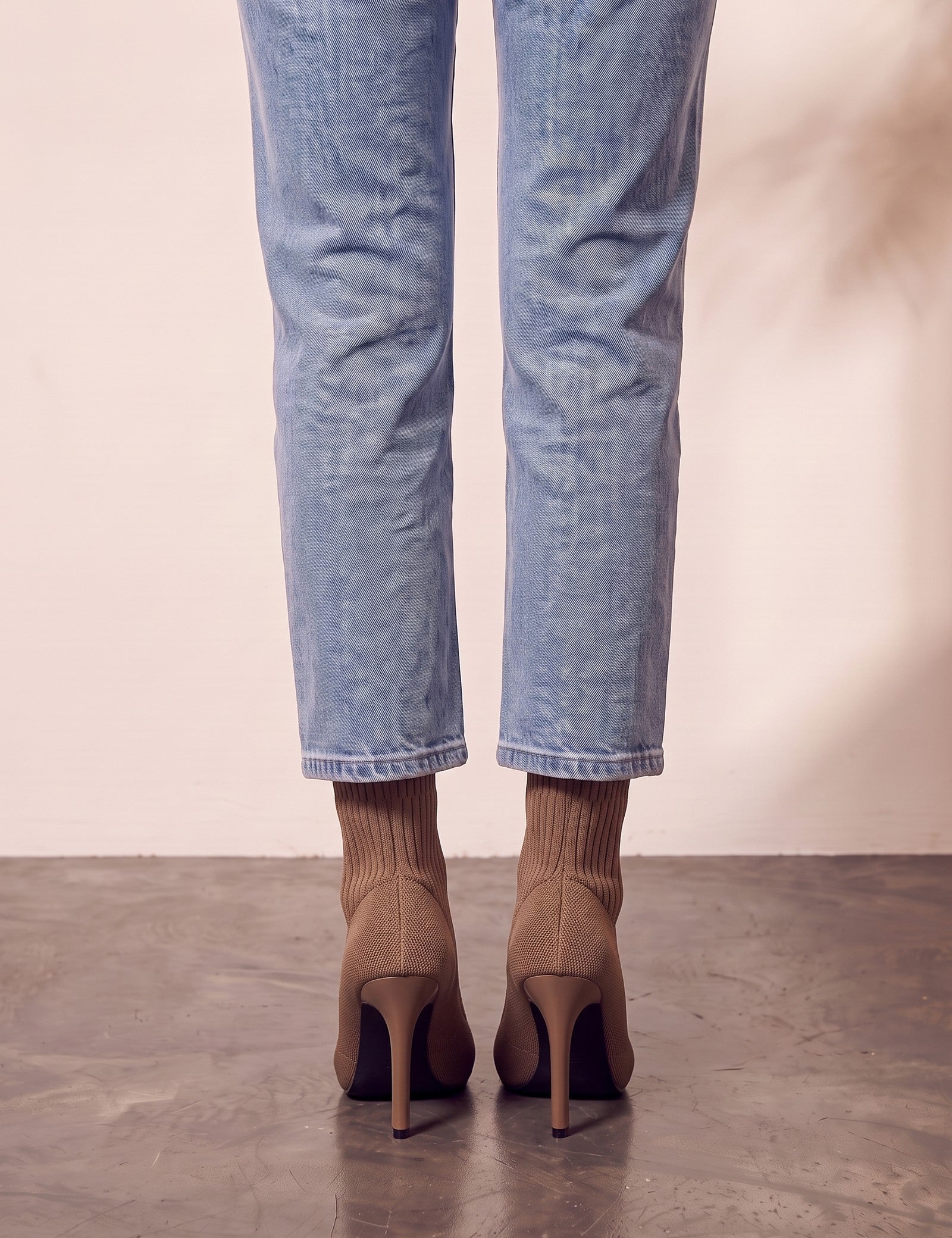 Women's Taupe Ribbed Knit Stiletto Sock Boots, back view of the heels, worn.