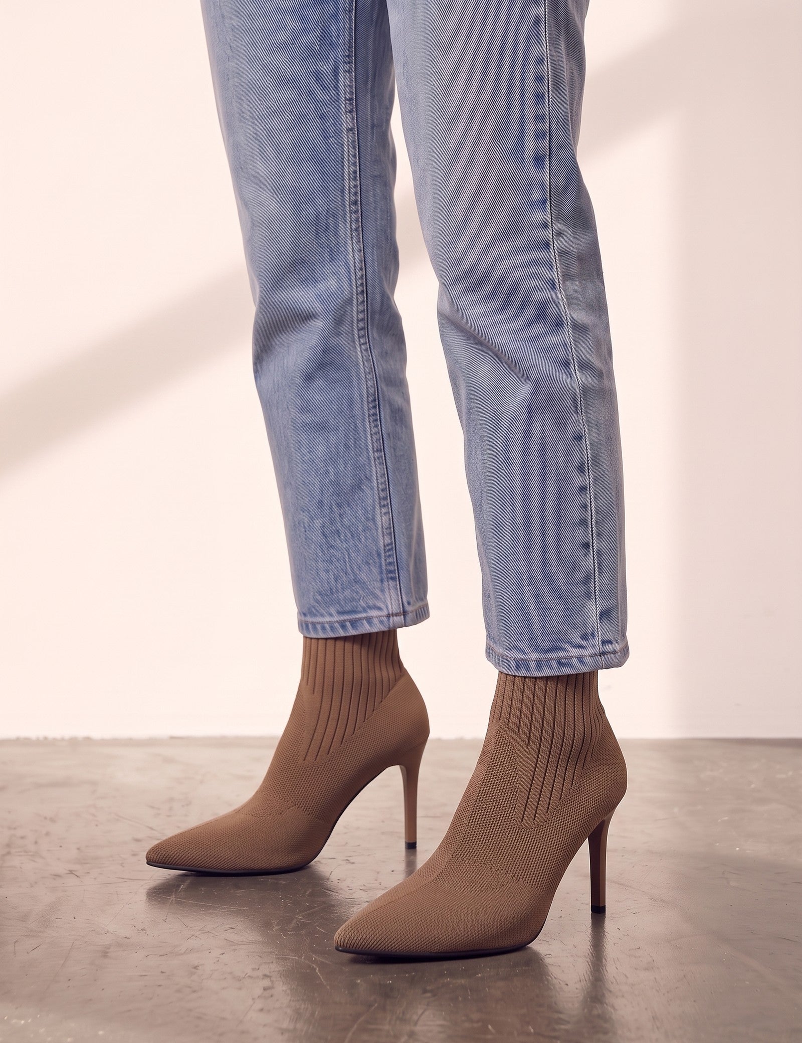 Women's Taupe Ribbed Knit Stiletto Sock Boots, side view of the shoe, worn.