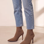 Women's Taupe Ribbed Knit Stiletto Sock Boots, three-quarter front view of the shoes, worn.