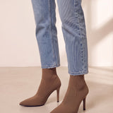 Women's Taupe Ribbed Knit Stiletto Sock Boots, three-quarter front view of the shoes, worn.