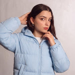 Women's Baby Blue Hooded Puffer Jacket with Pockets, close-up of the upper body.