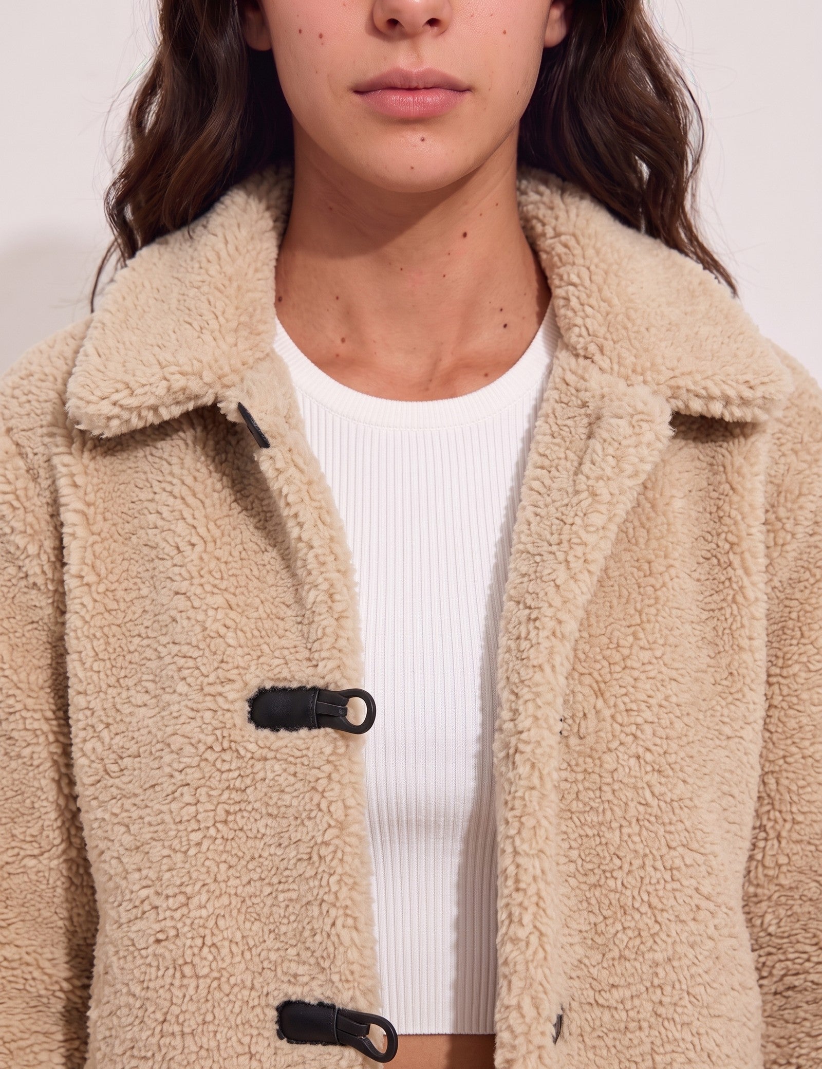 Women's Beige Teddy Jacket with Black Toggle Fastenings, close-up of the upper body.