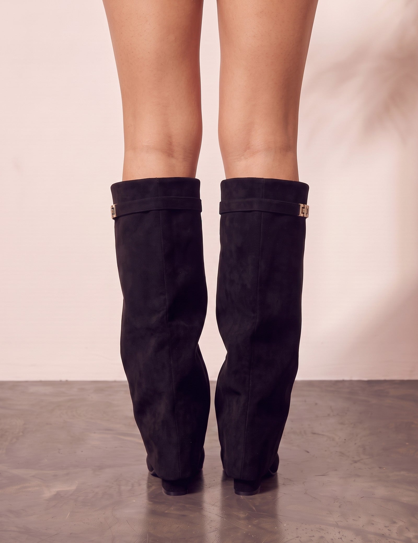 Women's Black Pointed-Toe Fold-Over Knee-High Boots, back view of the heels, worn.