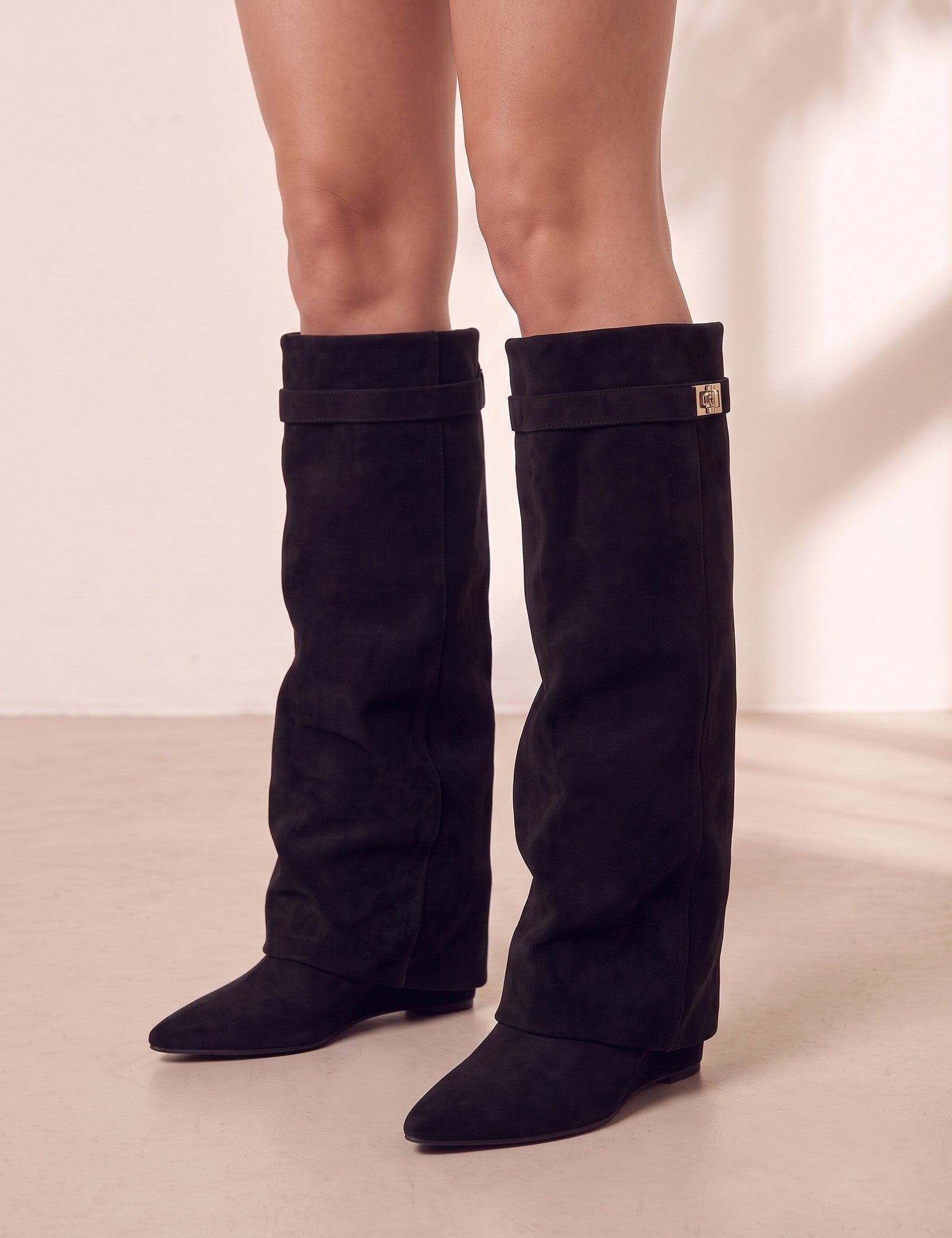 Women's Black Pointed-Toe Fold-Over Knee-High Boots, three-quarter front view of the shoes, worn.