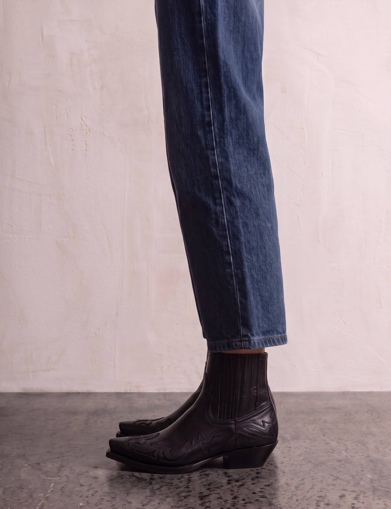Women's Black Western Ankle Boots with Pointed Toe, side view of the shoe, worn.