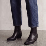 Women's Black Western Ankle Boots with Pointed Toe, three-quarter front view of the shoes, worn.