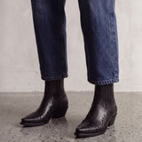 Women's Black Western Ankle Boots with Pointed Toe, three-quarter front view of the shoes, worn.