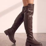 Women's Brown Leather-Look Platform Over-the-Knee Boots, the shoes in mid-step, showing the sole.