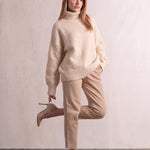 Women's Cream Relaxed Fit Roll Neck Jumper, three-quarter view from the left, full length.