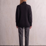Women's Relaxed Fit Roll Neck Jumper in Black, back view, full length.