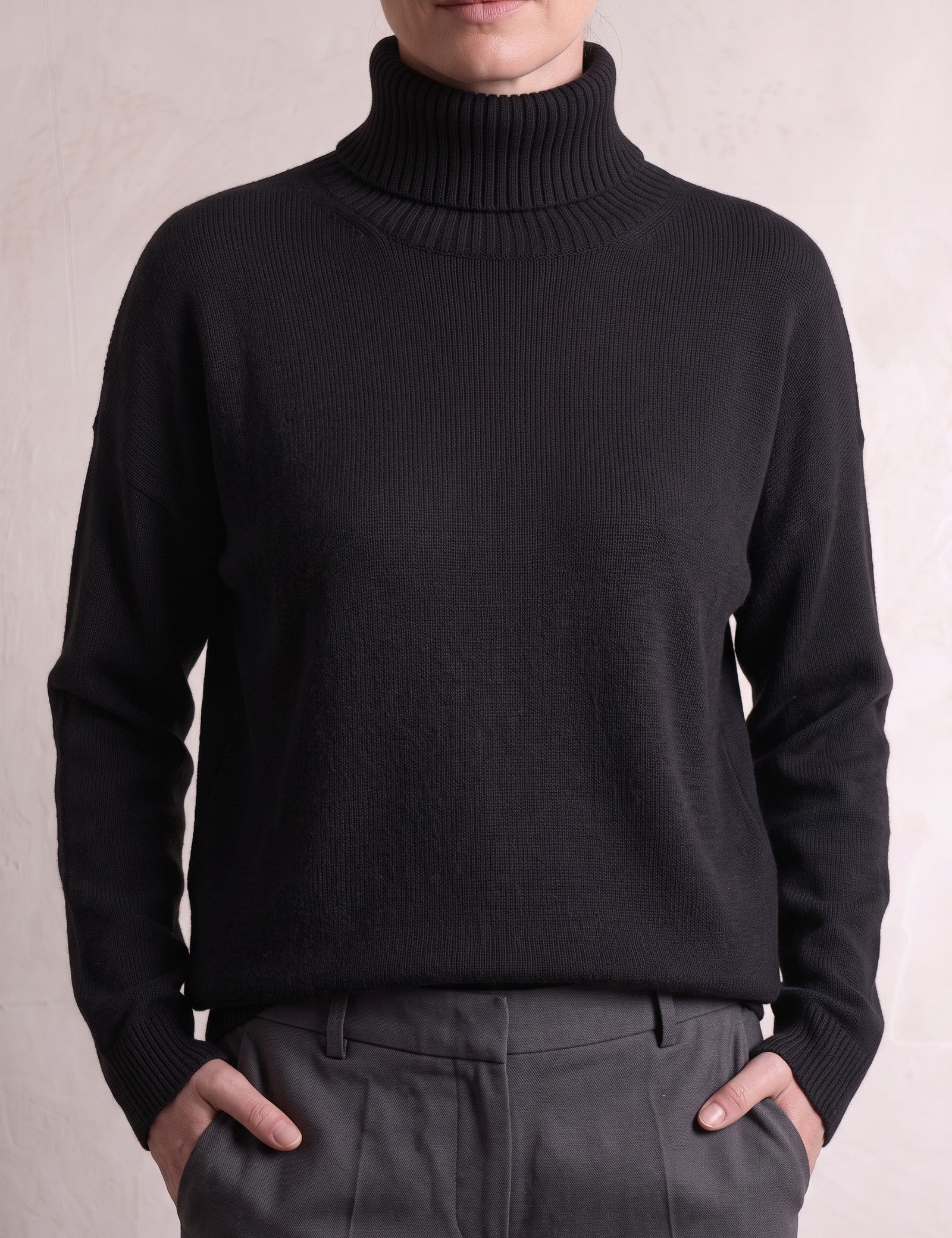 Women's Relaxed Fit Roll Neck Jumper in Black, close-up of the upper body.