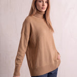 Women's Relaxed Fit Roll Neck Jumper in Camel, three-quarter view from the left, full length.