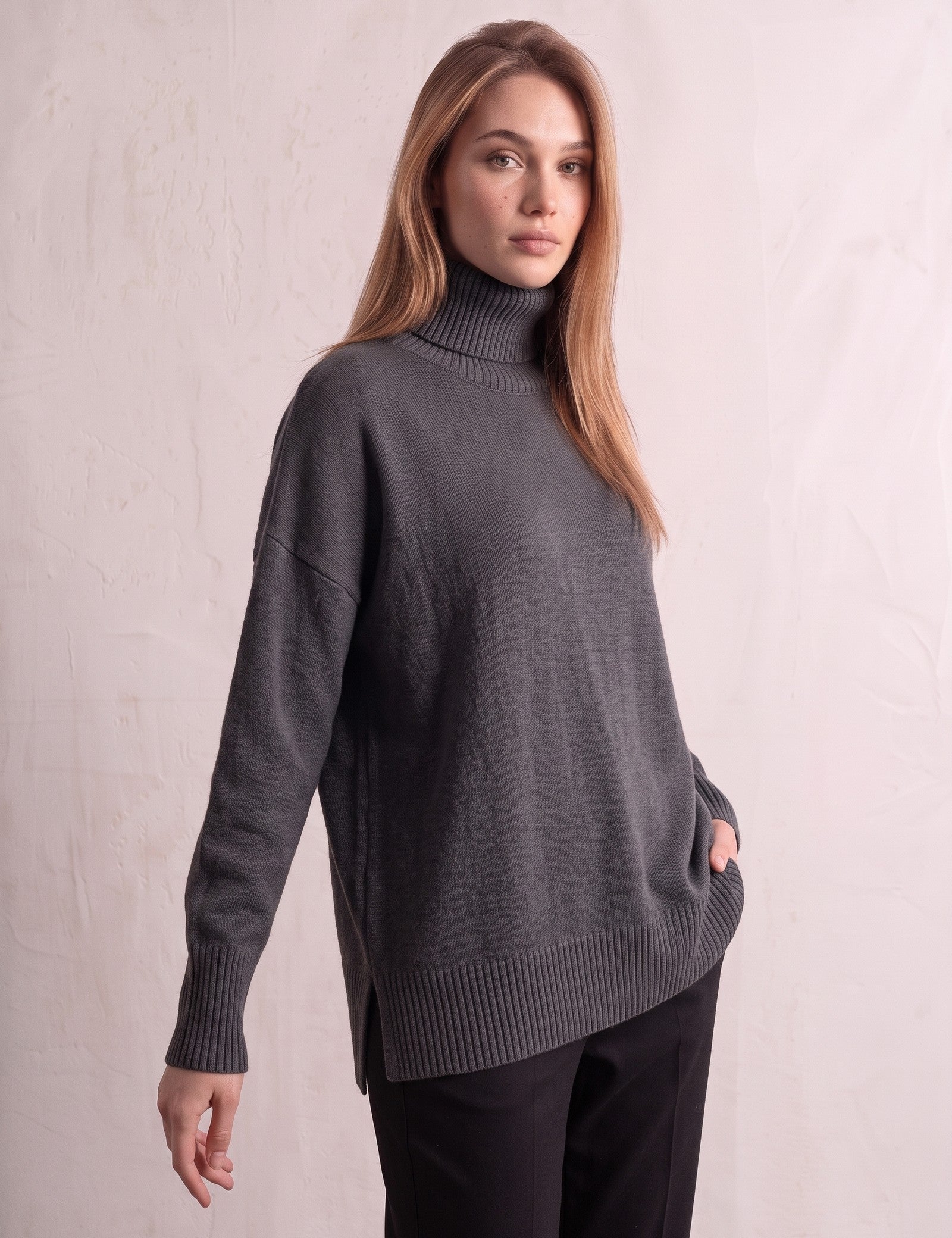 Women's Relaxed Fit Roll Neck Jumper in Dark Grey, three-quarter view from the left, full length.