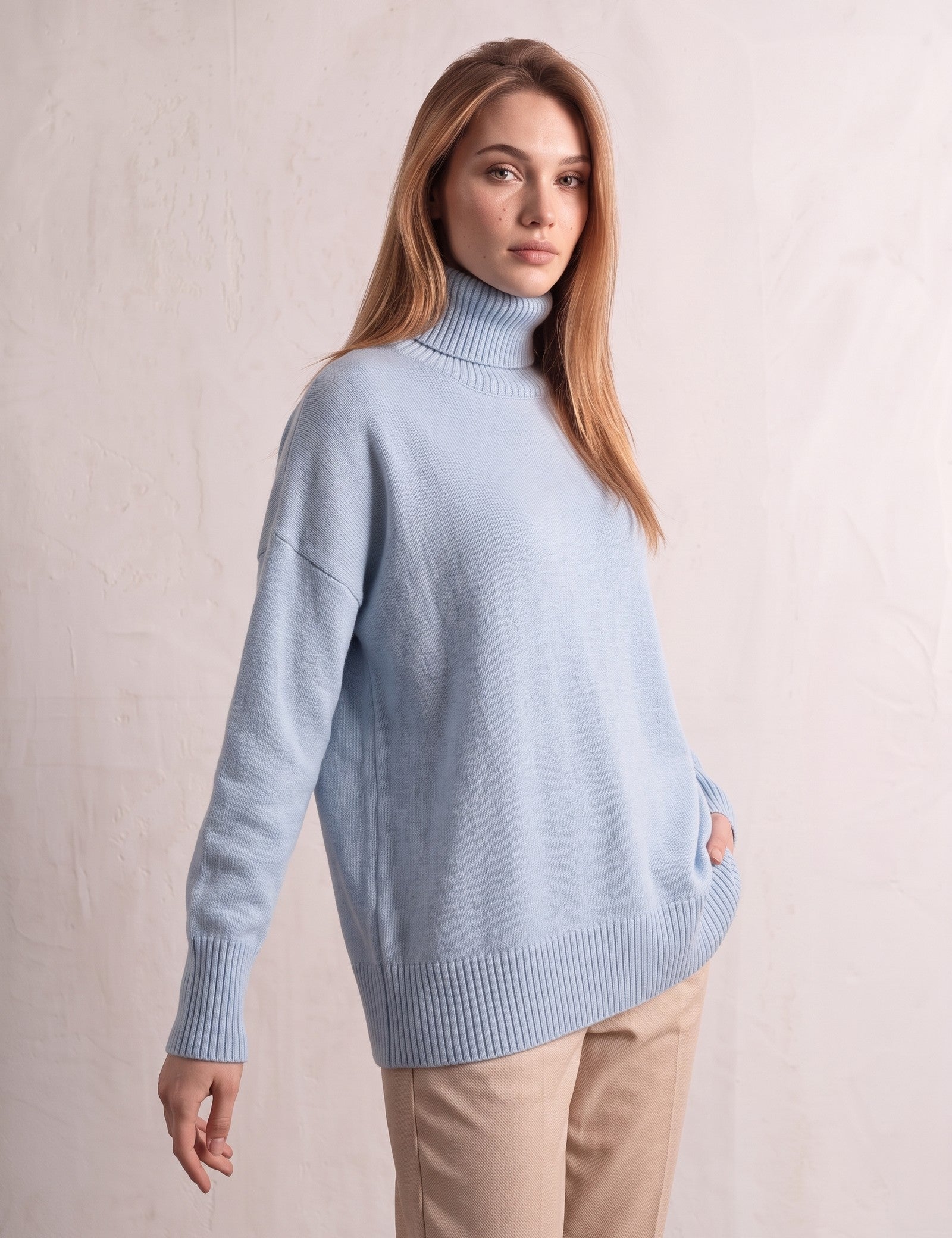 Women's Relaxed Fit Roll Neck Jumper in Light Blue, three-quarter view from the left, full length.